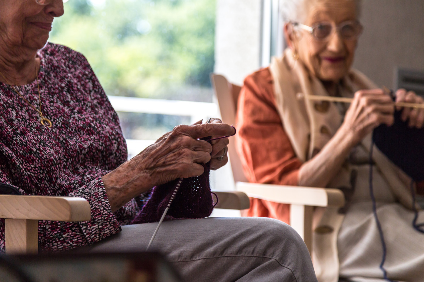 Elderly women knitting together indoors