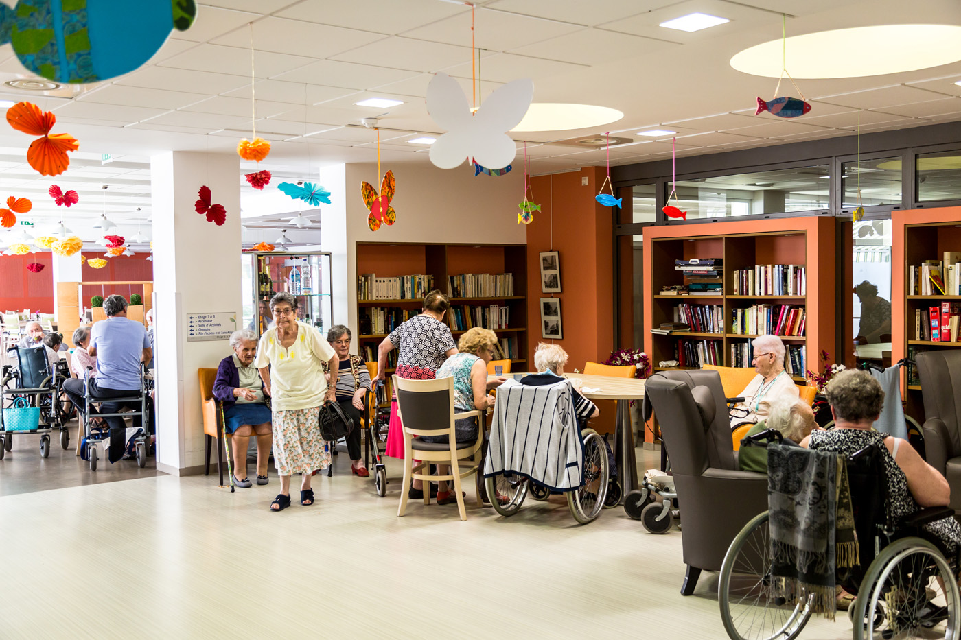 Elderly residents socializing in decorated nursing home lounge