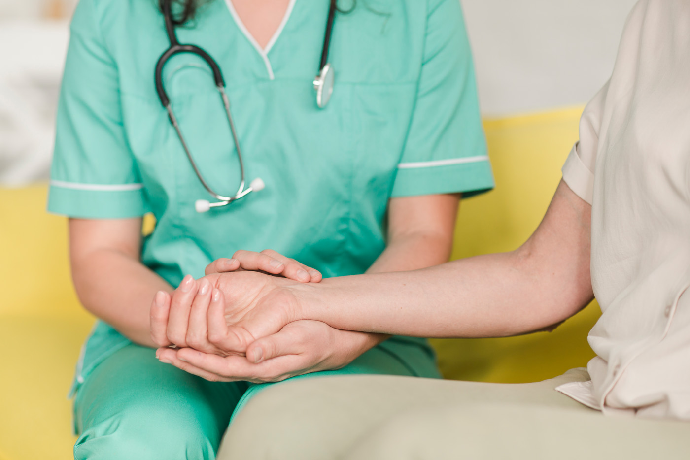 Nurse holding patient's hand in support